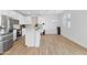 Kitchen featuring white cabinets, a center island, stainless steel appliances and wood-look floors at 16956 W Alice Ave, Waddell, AZ 85355