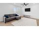 A simple living room with a sectional sofa, ceiling fan, and mounted tv at 16956 W Alice Ave, Waddell, AZ 85355