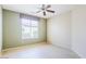 Bright bedroom featuring a ceiling fan and large window, offering ample natural light at 17192 W Hermosa Dr, Surprise, AZ 85387