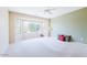 Spacious bedroom with plush carpet, a ceiling fan, and a large bay window offering ample natural light at 17192 W Hermosa Dr, Surprise, AZ 85387