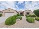 Charming single story home featuring a two car garage, manicured bushes, and desert landscaping at 17192 W Hermosa Dr, Surprise, AZ 85387