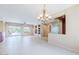 Open concept living room featuring tile floors, a decorative chandelier, and sliding glass doors at 17192 W Hermosa Dr, Surprise, AZ 85387