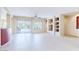 Bright living room featuring tile floors, a ceiling fan, built in display shelving, and sliding glass doors at 17192 W Hermosa Dr, Surprise, AZ 85387