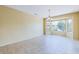 Bright living room featuring tile floors, a chandelier, and a large bay window for natural light at 17192 W Hermosa Dr, Surprise, AZ 85387