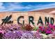 The Grand community sign is surrounded by colorful flowers, creating a welcoming entrance at 17192 W Hermosa Dr, Surprise, AZ 85387