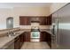 Efficient kitchen with stainless steel appliances, wooden cabinetry, and tile flooring at 18250 N 32Nd St # 1019, Phoenix, AZ 85032