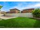 Enjoy the large grassy backyard with a sparkling pool, surrounded by a white block fence for privacy at 18563 W Fairway Dr, Surprise, AZ 85374