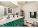 Bathroom with dual sinks, green cabinetry, and dark tile floors at 18563 W Fairway Dr, Surprise, AZ 85374