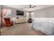 Spacious bedroom with soft carpet, neutral walls, ceiling fan, and a comfortable seating area at 18563 W Fairway Dr, Surprise, AZ 85374