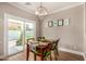 Bright dining area with wood table, chairs, chandelier, and sliding glass doors to the outdoor space at 18563 W Fairway Dr, Surprise, AZ 85374