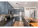 Spacious kitchen featuring custom blue cabinets, granite countertops, and stainless steel appliances at 18563 W Fairway Dr, Surprise, AZ 85374