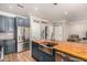 Kitchen with stainless appliances, a central island with a farmhouse sink and a wood countertop at 18563 W Fairway Dr, Surprise, AZ 85374