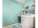 Functional laundry room with modern washer and dryer, featuring ample storage space on a shelf at 18563 W Fairway Dr, Surprise, AZ 85374