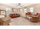 Large living room with a leather sofa and a ceiling fan, offering comfortable seating at 18563 W Fairway Dr, Surprise, AZ 85374