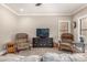 Spacious living area featuring stylish armchairs, a modern television setup, and comfortable seating at 18563 W Fairway Dr, Surprise, AZ 85374