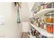 A walk-in pantry with wood floors and shelves stocked with an array of neatly organized jars at 18563 W Fairway Dr, Surprise, AZ 85374