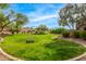 A picturesque park with green grass, shady trees, and convenient dog park equipment, inviting you to enjoy the outdoors at 18563 W Fairway Dr, Surprise, AZ 85374