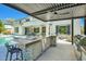 Luxurious backyard with a covered patio, pool, built-in kitchen, and ample space for entertaining at 1890 E Sagittarius Pl, Chandler, AZ 85249