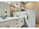 Elegant bathroom with double sinks, a large mirror, stylish lighting, and a walk-in shower at 1890 E Sagittarius Pl, Chandler, AZ 85249
