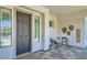 Front porch featuring neutral tiling, a black front door, and cozy seating at 1890 E Sagittarius Pl, Chandler, AZ 85249