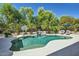 Refreshing backyard pool surrounded by lush landscaping, lounge chairs, and a charming waterfall feature at 1890 E Sagittarius Pl, Chandler, AZ 85249