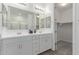 Bright bathroom featuring a dual sink vanity, walk-in shower and walk-in closet at 19873 W San Juan Ave, Litchfield Park, AZ 85340