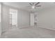 Bright bedroom with a ceiling fan, carpet flooring, and an attached bathroom with a walk-in closet at 19873 W San Juan Ave, Litchfield Park, AZ 85340