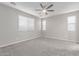 Spacious bedroom with neutral carpet, abundant natural light from several windows, and a ceiling fan at 19873 W San Juan Ave, Litchfield Park, AZ 85340