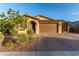 Gorgeous home with a three car garage, paver driveway, and meticulous desert landscaping under a blue sky at 19873 W San Juan Ave, Litchfield Park, AZ 85340
