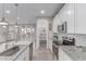 Well-designed kitchen with white cabinetry, granite counters, and stainless steel appliances, seamlessly flowing into the backyard at 19873 W San Juan Ave, Litchfield Park, AZ 85340