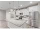Modern kitchen features stainless steel appliances, granite countertops, and a center island with pendant lighting at 19873 W San Juan Ave, Litchfield Park, AZ 85340