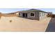 View of the backyard showcasing the home's exterior, windows, and block wall for privacy at 20274 W Monterey Way, Buckeye, AZ 85396