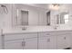 Bathroom with double vanity sinks, white cabinets, and a large mirror at 20274 W Monterey Way, Buckeye, AZ 85396