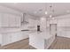 Bright kitchen with white cabinets, stainless steel appliances, large island, and wood-look flooring at 20274 W Monterey Way, Buckeye, AZ 85396