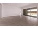 Bright and airy living room with wood-look tile floors and sliding glass doors to the outdoor space at 20274 W Monterey Way, Buckeye, AZ 85396