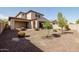 Spacious backyard boasts desert landscaping and a covered patio, ideal for outdoor living at 20473 W Legend Trl, Buckeye, AZ 85396