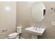 Elegant powder room with a pedestal sink, oval mirror, and neutral decor at 20473 W Legend Trl, Buckeye, AZ 85396