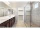 Bathroom featuring a double sink vanity, a glass-enclosed shower, and a walk-in closet at 20473 W Legend Trl, Buckeye, AZ 85396