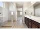 Bathroom featuring a large vanity with double sinks and a glass-enclosed shower at 20473 W Legend Trl, Buckeye, AZ 85396