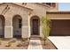Inviting front entrance featuring an arched entryway, a well-maintained walkway, and a manicured garden at 20473 W Legend Trl, Buckeye, AZ 85396