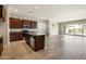 Spacious kitchen with dark wood cabinets, stainless steel appliances, and a granite countertop island with a sink at 20473 W Legend Trl, Buckeye, AZ 85396
