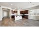 Kitchen with rich wood cabinets, a granite island, and stainless appliances, adjacent to a sunlit dining area at 20473 W Legend Trl, Buckeye, AZ 85396