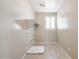 Bright laundry room with tile flooring, a shelf, and a window for natural light at 20473 W Legend Trl, Buckeye, AZ 85396