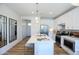 Modern kitchen boasts stainless steel appliances, white cabinets, an island with seating, and hardwood flooring at 2205 N Peden Dr, Chandler, AZ 85225