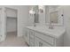 Modern bathroom featuring double sinks, sleek white cabinetry, and contemporary lighting fixtures at 23443 W Albeniz Pl, Buckeye, AZ 85326