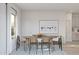Bright dining room featuring an oval table, modern chairs, and a vibrant beach-themed art print at 23443 W Albeniz Pl, Buckeye, AZ 85326