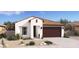 Charming single-story home with a brown roof, neutral stucco, a two-car garage and professionally landscaped front yard at 23443 W Albeniz Pl, Buckeye, AZ 85326
