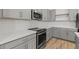 Modern kitchen features grey cabinets, quartz countertops, and stainless steel appliances at 23443 W Albeniz Pl, Buckeye, AZ 85326