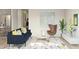 Cozy living area with a stylish blue sofa, unique egg chair, and a contemporary glass coffee table at 23443 W Albeniz Pl, Buckeye, AZ 85326