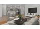 Open-concept living room and kitchen with sleek gray cabinets and stainless steel appliances at 23443 W Albeniz Pl, Buckeye, AZ 85326